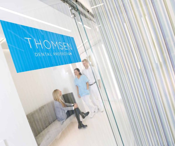 Dr. Thomsen im Gespräch mit zwei Mitarbeiterinnen in der Praxis von Dental Protection.