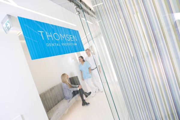 Dr. Thomsen im Gespräch mit zwei Mitarbeiterinnen in der Praxis von Dental Protection.